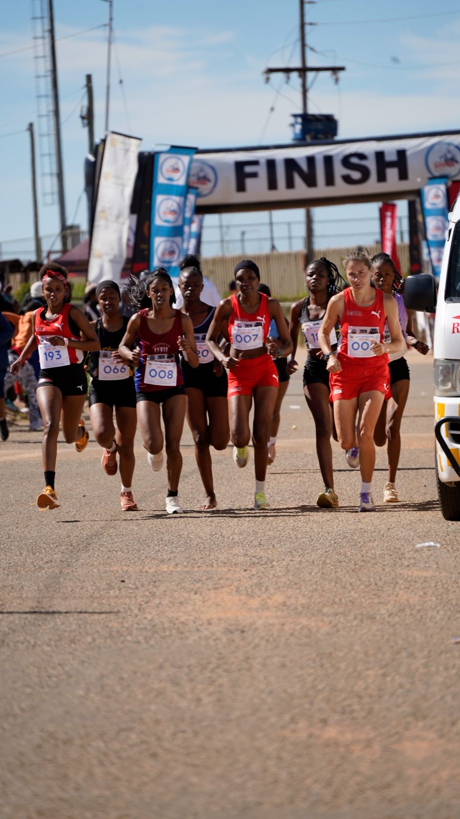 Women athletes running together near the finish line